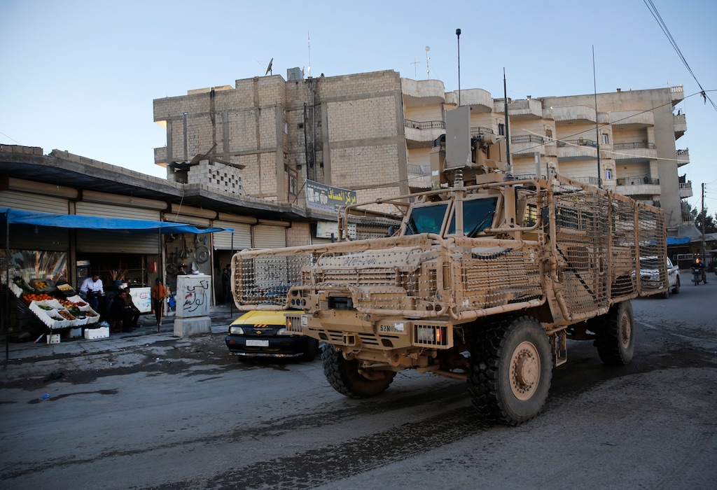 A vehicle of U.S. troops passes on a street, in Manbij town, north Syria, Saturday, March 31, 2018. President Donald Trump's unscripted public declaration this week about pulling out of Syria "very soon" while at odds with his own policy are unnerving for the Kurds in this context. U.S. troops first deployed in the area about 16 months ago, after Turkish-backed Syrian forces advanced on areas near Manbij, in a race for control of territories as IS militants collapsed. The deployment prevented repeated clashes between the two rival forces. (AP Photo/Hussein Malla)