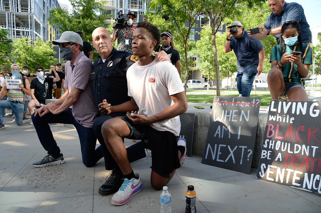 (Francisco Kjolseth  |  The Salt Lake Tribune) Salt Lake City Police Chief Mike Brown, center, takes a knee as he is joined by Robert Jenkins, left, and Aristide Gateretse, showing support of demonstrators protesting against police brutality on Wednesday, June 3, 2020, in downtown Salt Lake City, at the Salt Lake City Public Safety Building as the initially set 8 p.m. weeklong curfew was removed.