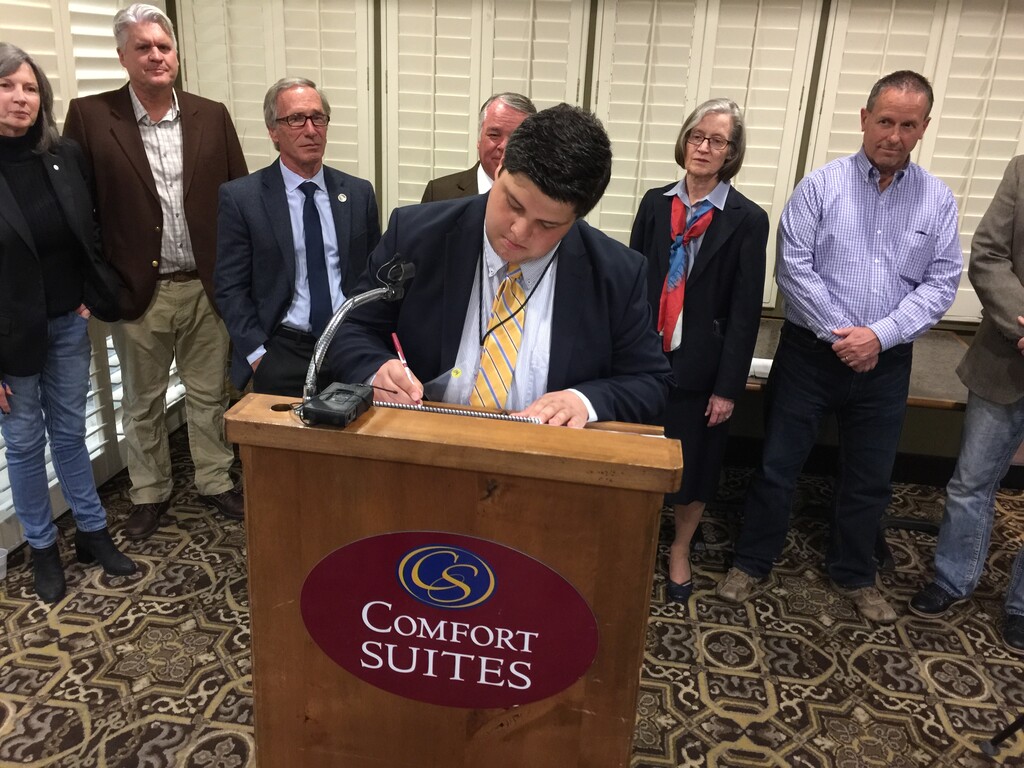 (Taylor Stevens | The Salt Lake Tribune) Weber County Forward Co-Chairman Oscar Mata signs a petition asking voters whether the county should form a commission to study a change to the county form of government.  Weber County’s current governance model has three full-time commissioners who serve 250,000 residents, but as the county continues to grow and become more diverse, members of the group said they want to see those residents have more representation.