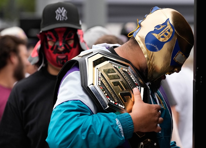 (Francisco Kjolseth | The Salt Lake Tribune) Andy, left, and Kevin Rosales wear traditional Mexican luchador masks for a picture opportunity with a UFC belt outside of Vivint Arena in Salt Lake on Saturday, Aug. 20, 2022, before the start of UFC 278 fights. 
