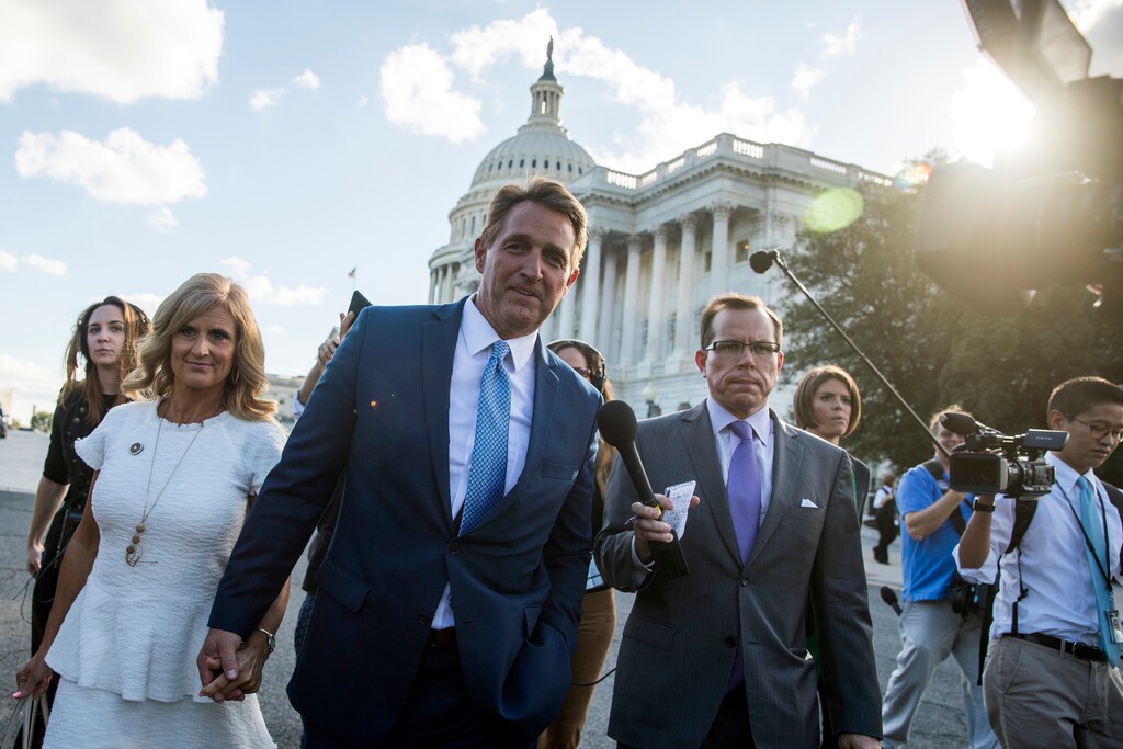 (AP Photo/Andrew Harnik) Sen. Jeff Flake, R-Ariz., accompanied by his wife, Cheryl, leaves the Capitol in Washington, Tuesday, Oct. 24, 2017, after announcing he won't seek re-election in 2018.