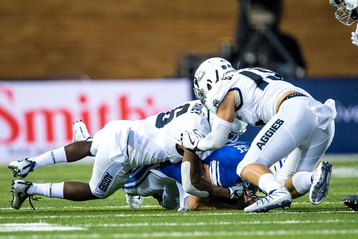 (Chris Detrick  |  The Salt Lake Tribune)  Brigham Young Cougars quarterback Beau Hoge (7) is tackled by Utah State Aggies cornerback Cameron Haney (6) and Utah State Aggies safety Baron Gajkowski (15) the game at Merlin Olsen Field at Maverik Stadium Friday, September 29, 2017.