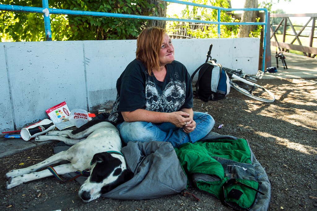 (Chris Detrick  |  The Salt Lake Tribune) Nicole, 40, and dog, Bonnie, rest along the Jordan River Parkway Trail in Salt Lake City Friday, Aug. 18, 2017.