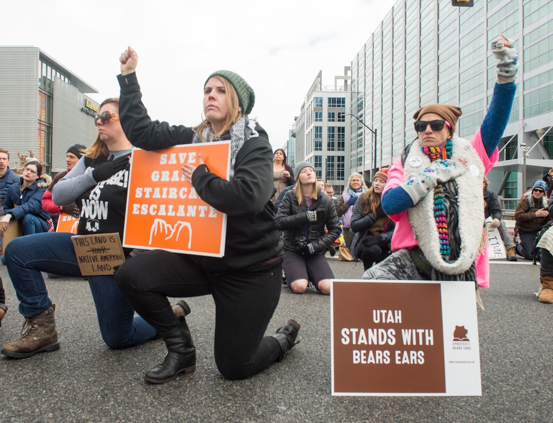 (Rick Egan  |  The Salt Lake Tribune)  Protesters kneel down as they block traffic on State Street, while protesting President Trump's visit to Salt Lake City to shrink two national monuments, Monday, December 4, 2017.