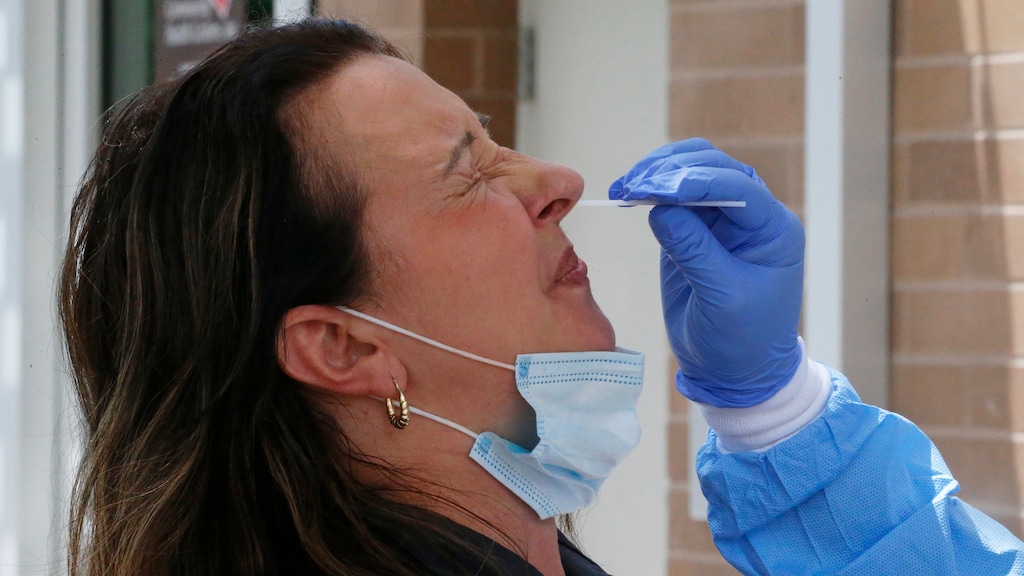 A woman receives a coronavirus test from Salt Lake County Health Department public health nurse Lee Cherie Booth outside the Salt Lake County Health Department Friday, June 12, 2020, in Salt Lake City. Utah and Oregon put any further reopenings of their economies on hold amid a spike in coronavirus cases, but there was no turning back Friday, June 12, 2020, in such states as Texas, California, Arkansas and Arizona despite flashing warning signs there, too. (AP Photo/Rick Bowmer)