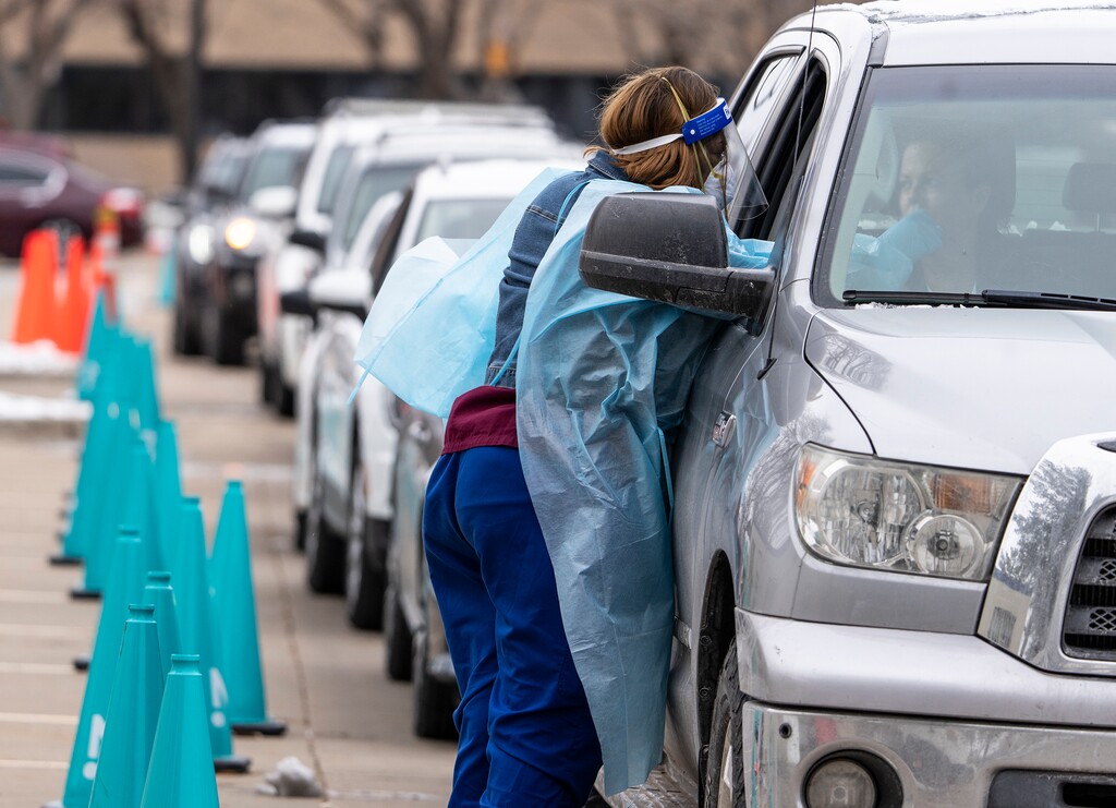 (Leah Hogsten | The Salt Lake Tribune) A steady line of vehicles filled with multiple people waiting to be tested for Covid19 are tended to by members of the Utah Department of Health at the Cannon Health Building, Dec. 27, 2021. 