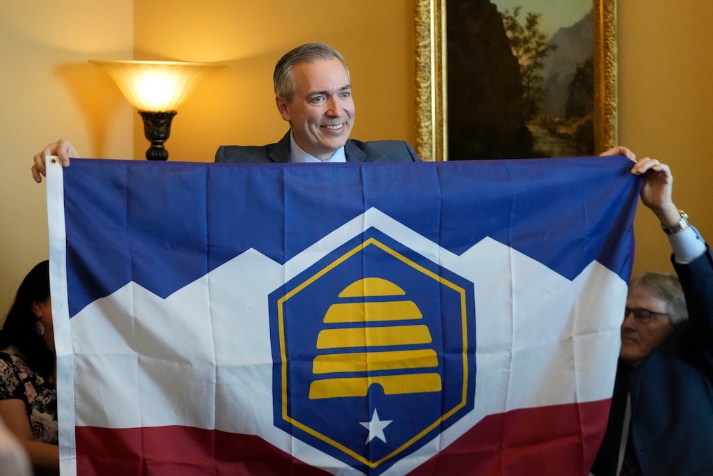 (Rick Bowmer | AP) Utah Sen. Dan McCay, R-Riverton, unfurls the state's new flag during a Senate media availability on Thursday, March 2, 2023, in Salt Lake City. Opponents of the new state flag have filed a referendum in an attempt to bypass the Legislature and let voters decide on the design.