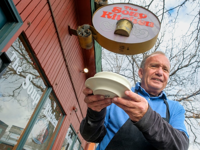 (Leah Hogsten | The Salt Lake Tribune) Drake Aitken serves up The Soup Kitchen's most popular chicken noodle soup, Dec. 18, 2020.