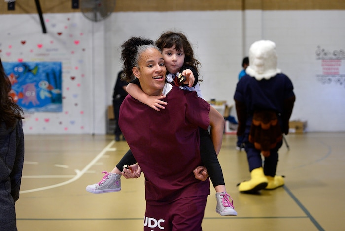 (Scott Sommerdorf   |  The Salt Lake Tribune)   Inmate Angela Rekoutis carries her daughter Ava on her back during "Kids Day" in the gym at the Utah State Prison, Saturday, October 7, 2017. The day allows incarcerated mothers an extended visit with their children for events and activities not allowed during regular visits - including meals, games and craft projects.