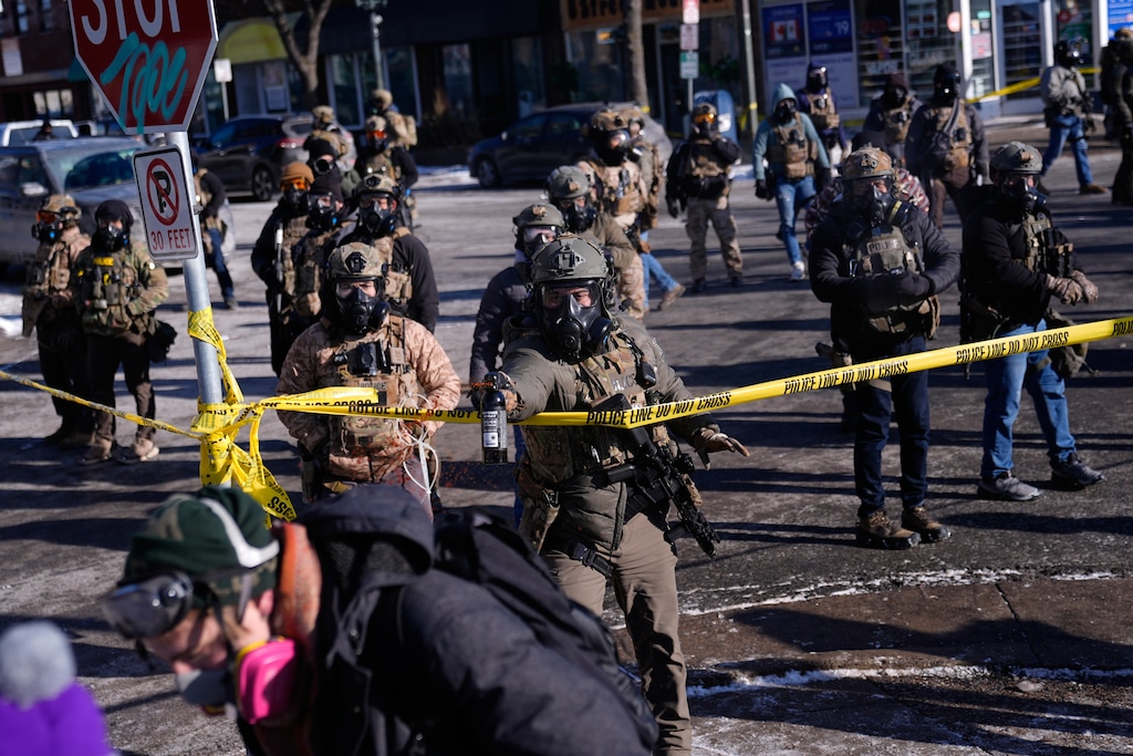 Federal immigration officers deploy pepper spray at protesters after a shooting Saturday, Jan. 24, 2026, in Minneapolis. (AP Photo/Abbie Parr)
