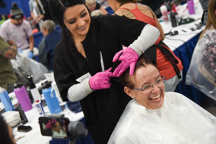 (Francisco Kjolseth  |  The Salt Lake Tribune)  Liza Parker gets a fresh haircut from Dallas Halverson as she laughs after saying "just fix it, I cut it with the kitchen scissors," during Salt Lake CityÕs second annual Project Homeless Connect at the Salt Palace Convention Center on Friday, Oct. 12, 2018.