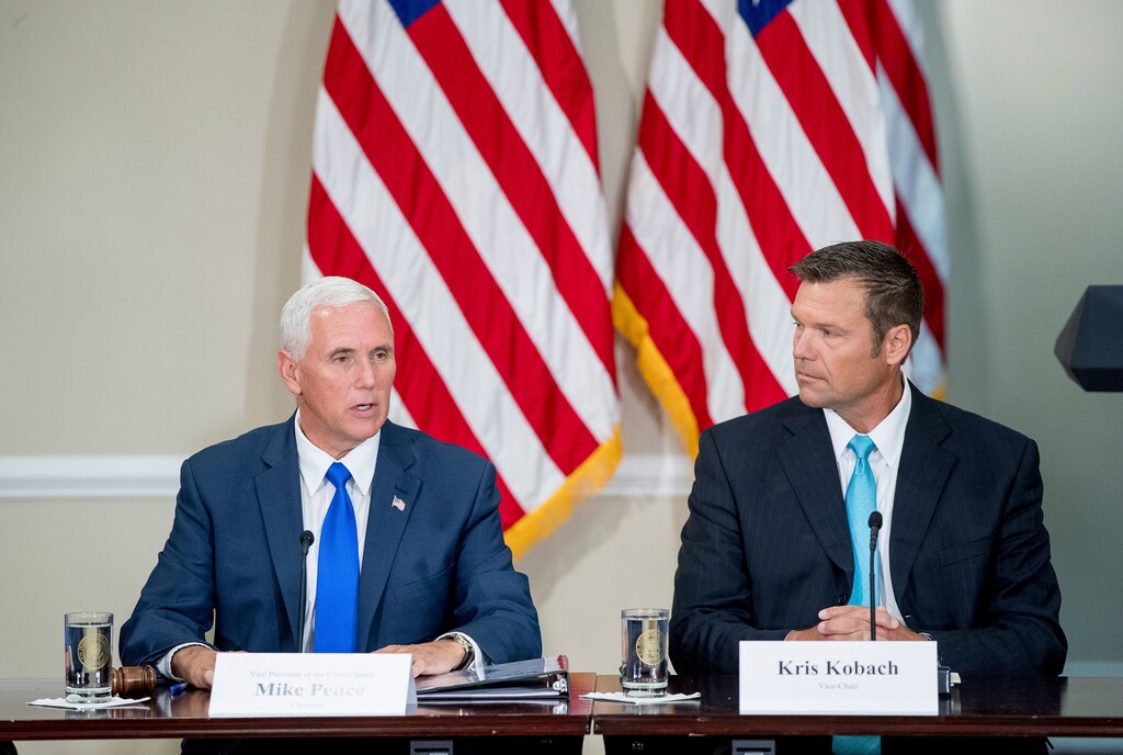 Vice President Mike Pence, left, accompanied by Kansas Secretary of State Kris Kobach, right, speaks during the first meeting of the Presidential Advisory Commission on Election Integrity at the Eisenhower Executive Office Building on the White House complex in Washington, Wednesday, July 19, 2017. (AP Photo/Andrew Harnik)
