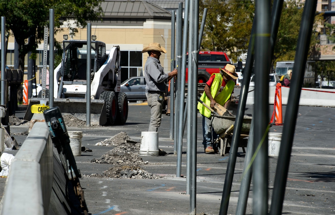 (Steve Griffin  |  The Salt Lake Tribune) Workers cement  fence posts into position on Rio Grande Street in Salt Lake City Monday September 11, 2017.