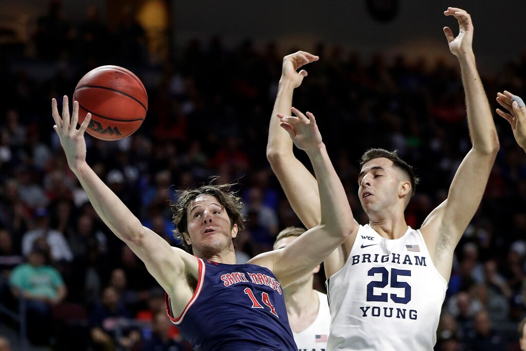 Saint Mary's Kyle Bowen (14) and BYU's Gavin Baxter (25) reach for a rebound during the first half of an NCAA college basketball game in the West Coast Conference tournament, Monday, March 9, 2020, in Las Vegas. (AP Photo/Isaac Brekken)