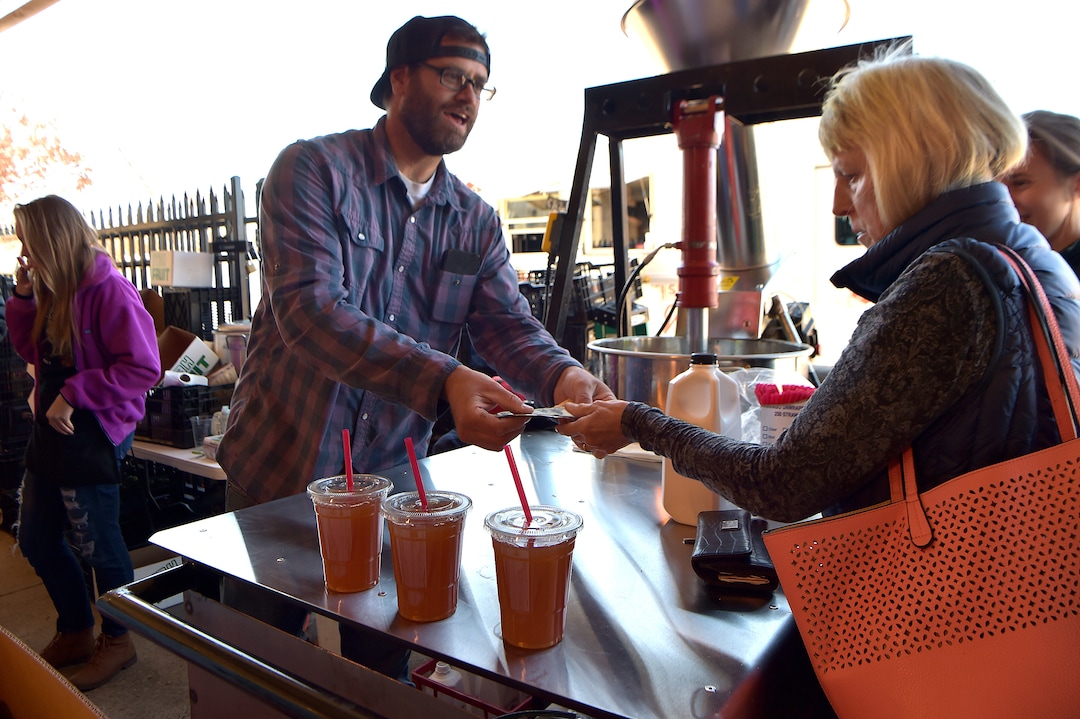 (Scott Sommerdorf   |  The Salt Lake Tribune)   Kent Pyne sells some of his fresh pressed apple juice at the Pyne Farms booth at the Rio Grande Winter Market, Saturday, November 11, 2017. 