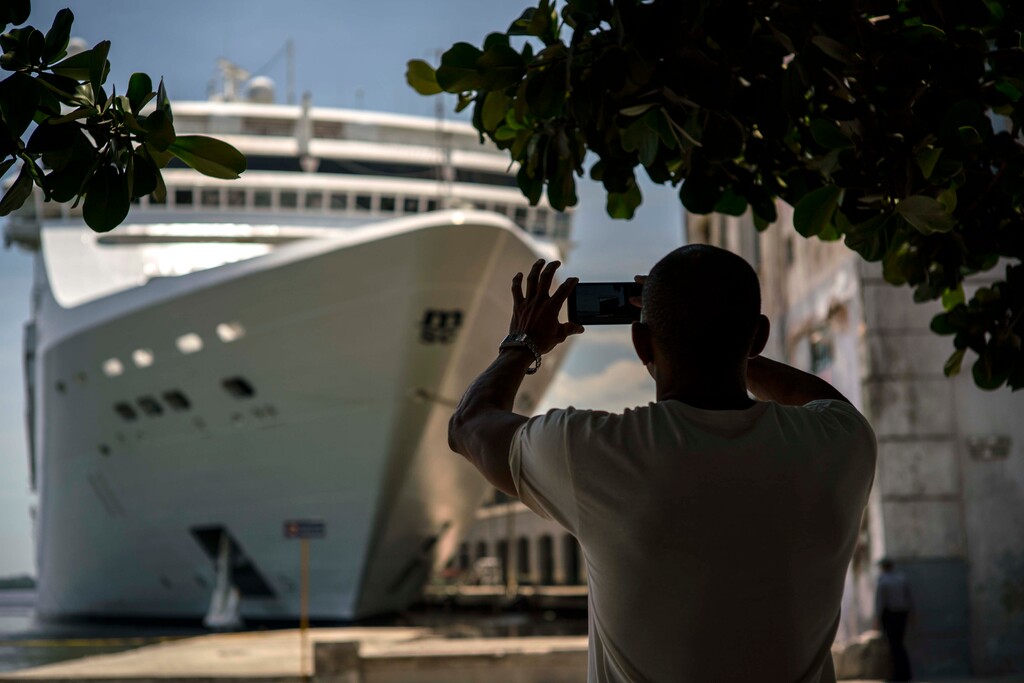 (Ramon Espinosa | The Associated Press) In this June 17, 2017, file photo, a man takes a photo of a cruise ship in Havana harbor, Cuba. President Donald Trump announced a new policy in June that partially rolled back the recent diplomatic opening with Cuba. New regulations implementing that policy are being unveiled Wednesday.