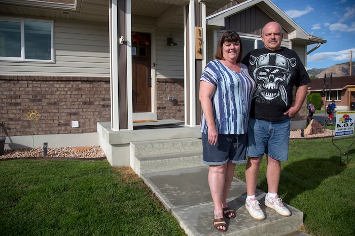(Benjamin Zack | Standard-Examiner via AP) Gaelynn and Paul Sewell stand in front of their new home in Washington Terrace on Thursday, Sept. 14, 2017. The Sewell's home of 22 years was destroyed by the tornado that struck Washington Terrace on Sept. 22, 2016. They recently moved into their new home at the same location.