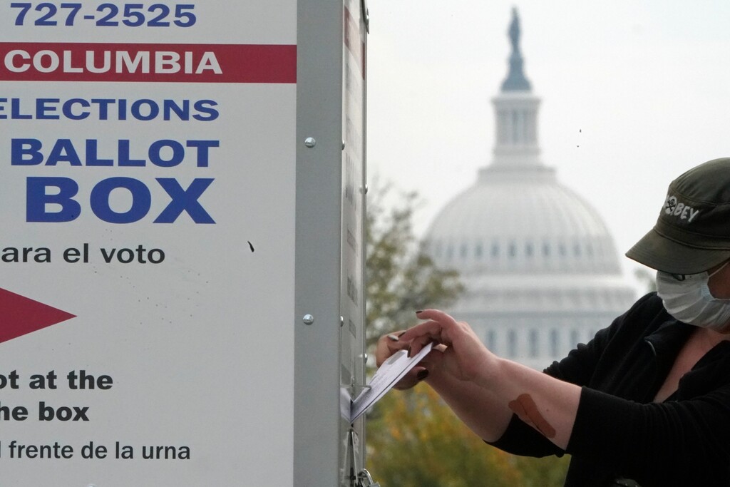 (Patrick Semansky | AP file photo)  With the U.S. Capitol dome visible, a voter drops a ballot into an early voting drop box, Wednesday, Oct. 28, 2020, at Union Market in Washington.