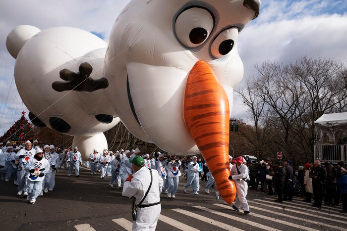 (Mark Lennihan | AP) A balloon handler holds the Olaf balloon by the nose as strong winds keep Macy's Thanksgiving Day Parade balloons low to the ground, Thursday, Nov. 28, 2019, in New York.