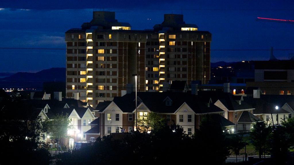 (Steve Griffin  |  The Salt Lake Tribune)  Traditional lighting creates glare near student housing, front, on the University of Utah campus in Salt Lake City. A "hooded" fixture, which directs light toward the ground, stands at the center of the scene.