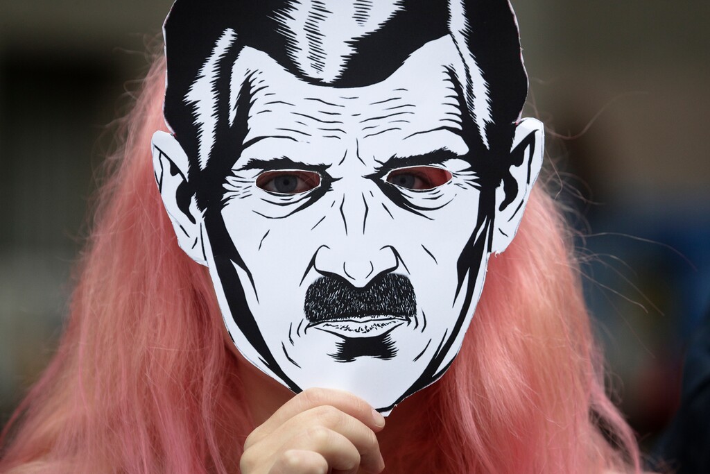 A woman wears a face mask depicting the Big Brother character from George Orwell's novel Nineteen Eighty-Four, as they attend a protest rally 'For freedom on the Internet', in St.Petersburg, Russia, Sunday, July 16, 2017. About 30 activists gathered in central St.Petersburg to protest against the thoughtcrime censorship by the state on the Internet in Russia. (AP Photo/Dmitri Lovetsky)