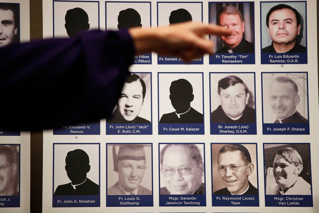 FILE - In this Thursday, Dec. 6, 2018 file photo, a sexual abuse victim points to the photos of Catholic priests accused of sexual misconduct by victims during a news conference in Orange, Calif. (AP Photo/Jae C. Hong)