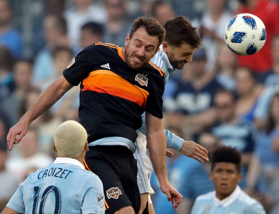 Houston Dynamo midfielder Eric Alexander, top left, heads the ball against Sporting Kansas City midfielder Ilie Sanchez, top right, during the first half of an MLS soccer match in Kansas City, Kan., Saturday, June 23, 2018. (AP Photo/Orlin Wagner)