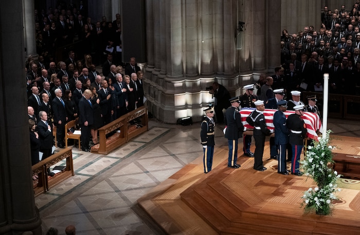 The flag-draped casket of former President George H.W. Bush is carried by a military honor guard past former President George W. Bush and wife Laura Bush, President Donald Trump, first lady Melania Trump, former President Barack Obama, Michelle Obama, former President Bill Clinton, former Secretary of State Hillary Clinton, former President Jimmy Carter, and Rosalynn Carter during a State Funeral at the National Cathedral, Wednesday, Dec. 5, 2018, in Washington. (AP Photo/Carolyn Kaster)