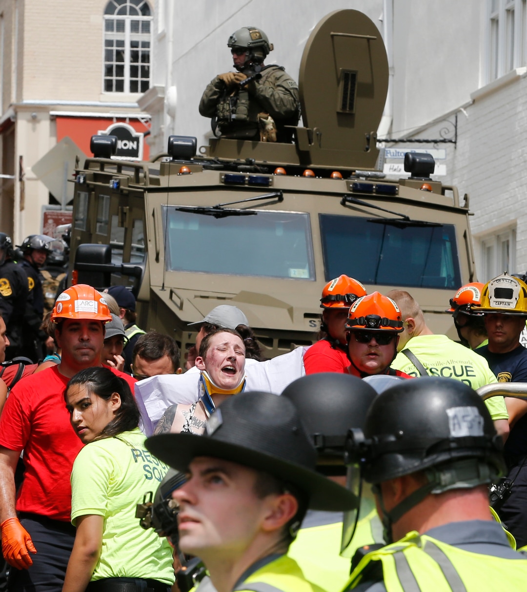 (Steve Helber  |  AP Photo)  Rescue personnel help injured people after a car ran into a large group of protesters after an white nationalist rally in Charlottesville, Va., Saturday, Aug. 12, 2017. The nationalists were holding the rally to protest plans by the city of Charlottesville to remove a statue of Confederate Gen. Robert E. Lee. There were several hundred protesters marching in a long line when the car drove into a group of them.