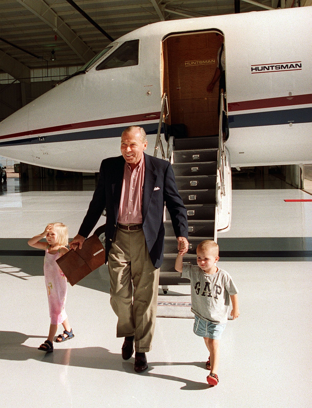 (Tribune file photo) Jon Huntsman exits a company plane with two of his grandchildren, Madeline and Paul Jr., in this July 1999 photo.