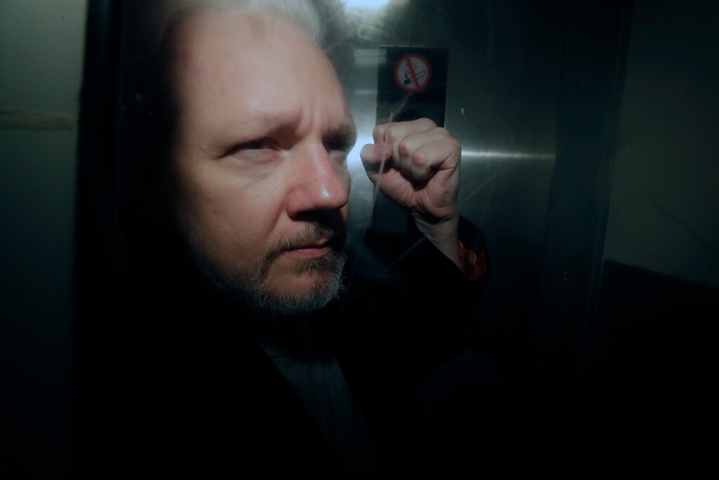 (Matt Dunham | AP Photo) In this May 1, 2019 photo, WikiLeaks founder Julian Assange puts his fist up as he is taken from court in London. The Justice Department has charged Assange with receiving and publishing classified information. The charges are contained in a new, 18-count indictment announced May 23, 2019.