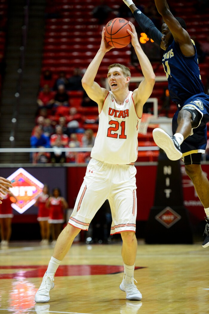 (Steve Griffin  |  The Salt Lake Tribune)  Utah Utes forward Tyler Rawson (21) fakes UC Davis Aggies guard Michael Onyebalu (31) into the air during the Utah versus UC Davis men's NIT basketball game at the Huntsman Center in Salt Lake City Wednesday March 14, 2018.