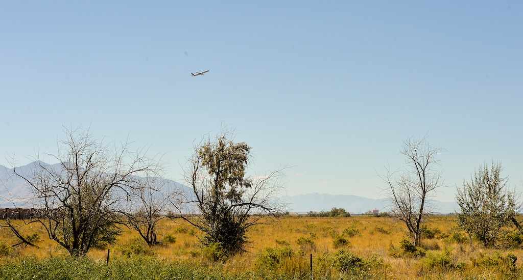 (Chris Samuels | The Salt Lake Tribune) An airplane takes off over undeveloped land in the Northpoint neighborhood of Salt Lake City in September 2022. Residents of the area have come under pressure to sell their homes to developers wanting to build commercial warehouse space in one of the last agricultural areas of Salt Lake City.