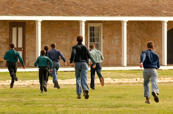 (Trent Nelson | The Salt Lake Tribune)
San Angelo, Texas - A group of FLDS boys run from journalists at Fort Concho after being ordered away by Texas Child Protective Services officials. Soon CPS would separate the mothers from their children and spread the children throughout the state into foster care.