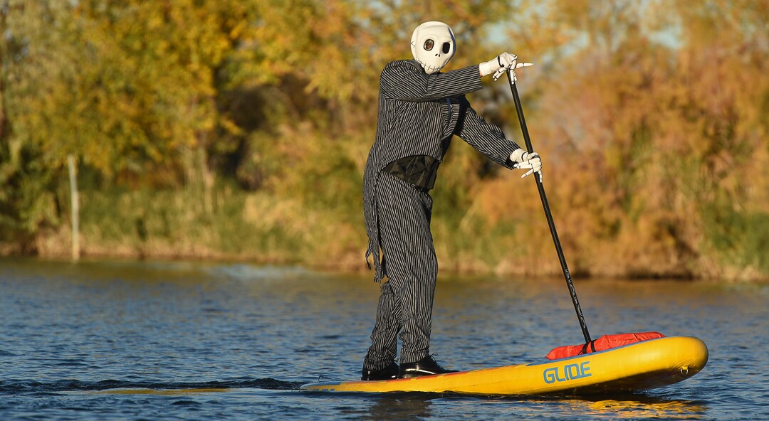 (Francisco Kjolseth  |  The Salt Lake Tribune)  Stand up paddle board enthusiast Chris Knoles takes to the water at Bountiful Pond on Tuesday, Oct. 30, 2018, in what has become a Halloween tradition for the 4th year in a row as they dress up this year as Jack and Sally Skellington from the movie Nightmare Before Christmas. "We paddle year round but actually paddle more in the winter," exclaimed Knoles, who carry the tradition on at Christmas, dressing up in something festive and paddling on the Great Salt Lake where the high salinity usually keeps the water from freezing.