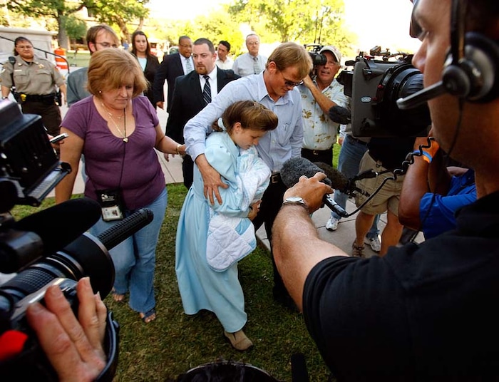 (Trent Nelson | The Salt Lake Tribune)
San Angelo, Texas - FLDS member Dan Jessop and his wife Louisa Bradshaw wade through media cameras as they leave the Tom Green County Courthouse after a custody hearing on the status of their newborn son. CPS had refused proof that Bradshaw was an adult until her child was born in state custody, at which point they sought to take custody of the newborn. Bradshaw did her case no good by refusing to answer such seemingly simple questions as who attended her wedding and who else lived in her home.