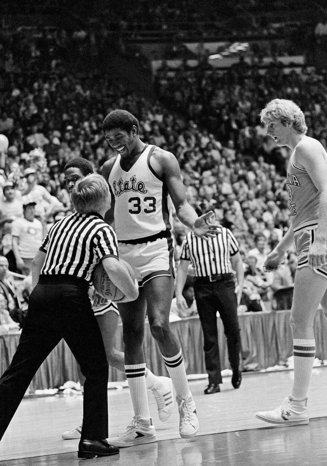 (AP Photo) Michigan State's Earvin "Magic" Johnson smiles at the referee as he gets a foul called on him during NCAA Basketball Championship game Monday, March 26, 1979 at Salt Lake City, Utah. At right is Indiana State's Larry Bird. 