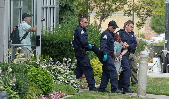 (Francisco Kjolseth  |  The Salt Lake Tribune)  Activists are removed from a building where they staged a protest against a private prison company with contracts to hold undocumented immigrants on Thursday, July 12, 2018, at the headquarters of Management and Training Corporation in Centerville.