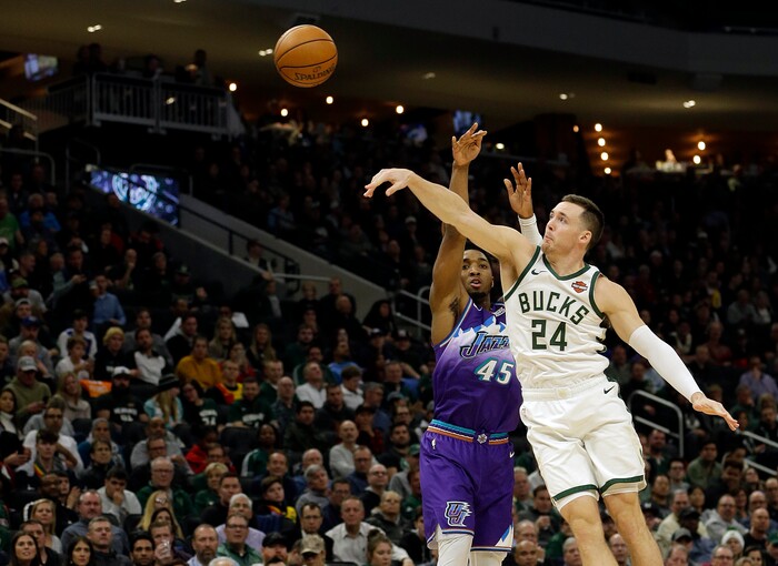 Milwaukee Bucks' Pat Connaughton (24) blocks the shot of Utah Jazz's Donovan Mitchell (45) during the second half of an NBA basketball game Monday, Nov. 25, 2019, in Milwaukee. (AP Photo/Aaron Gash)