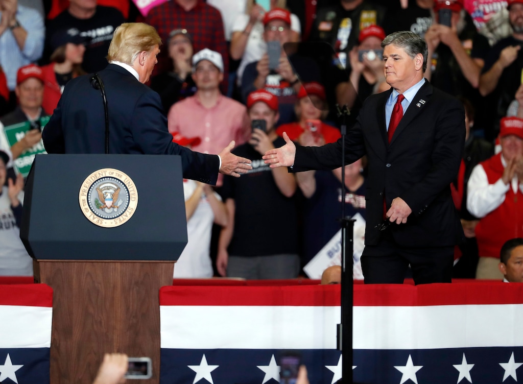 President Donald Trump shakes hands with Fox News Channel's Sean Hannity, right, during a campaign rally Monday, Nov. 5, 2018, in Cape Girardeau, Mo. (AP Photo/Jeff Roberson)
