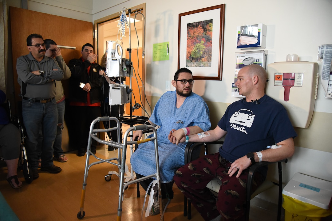 (Francisco Kjolseth  |  The Salt Lake Tribune)  Mitchell Salas, 30, center, holds the hand of the man who saved his life when Matthew Thompson, 32, a good samaritan organ donor at Intermountain Medical Center generously donated his kidney to him. The two men are now "brothers for life" in the words of Salas who has battled kidney troubles since he was a baby. The two, who are still in the hospital met for the first time on Friday, March 29, 2019. Mitchell's father Willie Salas, at left, exclaimed "thank you for giving life back to my boy."