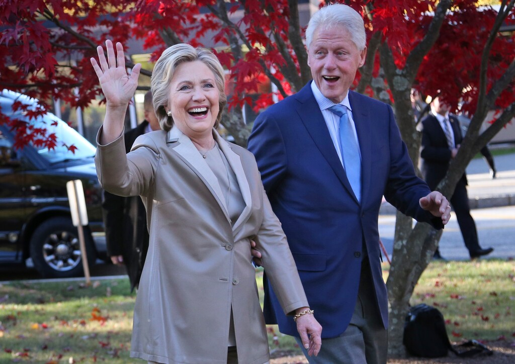 FILE - In this Nov. 8, 2016 file photo, Hillary Clinton and her husband, former President Bill Clinton, greet supporters after voting in Chappaqua, N.Y. Falling in line with tradition, Bill and Hillary Clinton plan to attend Donald Trump's inauguration. It’s a decision that will put Hillary Clinton on the inaugural platform as her bitter rival from the 2016 campaign assumes the office she long sought.  (AP Photo/Seth Wenig, File)