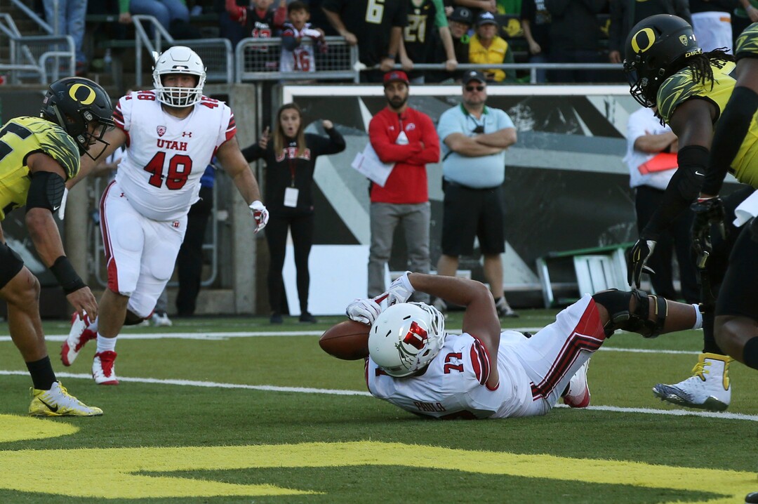 Utah's Darrin Paulo, center right, catches a tipped pass for a touchdown against Oregon during the third quarter of an NCAA college football game Saturday, Oct. 28, 2017, in Eugene, Ore. (AP Photo/Chris Pietsch)