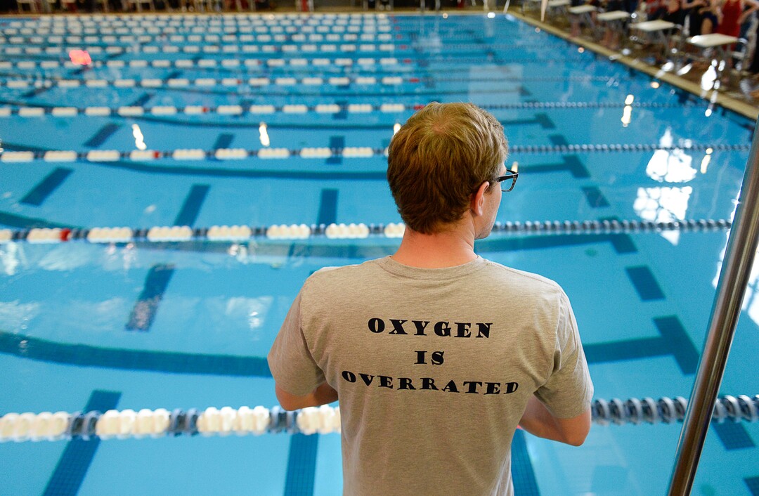 (Francisco Kjolseth  |  The Salt Lake Tribune)  Corner Canyon coach Jayden Rasband keeps en eye on the start of the high school swimming 5A State Championships in Bountiful, Friday February 9, 2018.