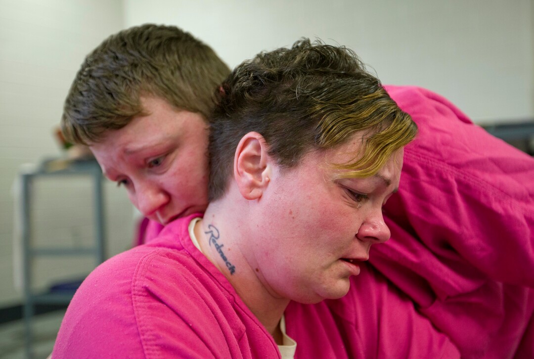 Inmate Mary Sammons, 41, foreground, is comforted in the Campbell County Jail in Jacksboro, Tenn., Wednesday, March 28, 2018, by cellmate Blanche Ball, 30, days after Sammons learned that her 20-year-old son was murdered in Kentucky. Sammons, who was arrested on drug-related charges, suspects her son's murder was drug-related. "I always pictured my kids burying me, not me having to bury my children. Young kids are losing their life over bad dope. This is crazy. It's so not worth it. He was a pretty boy. He was beautiful." (AP Photo/David Goldman)