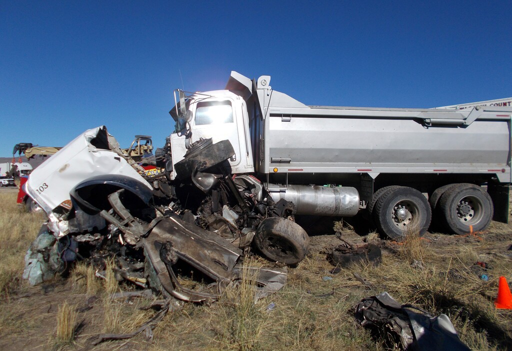 This Friday, Oct. 19, 2018 photo provided by the Utah Highway Patrol shows the scene of a head-on collision of a dump truck and a pickup on a state highway near Heber, Utah. State troopers say the dump truck crossed a highway median and collided with the pickup truck traveling in the opposite direction, killing all six men in the pickup in an accident authorities suspect may was caused by alcohol and prescription drugs. The Utah Highway Patrol said Saturday its officers found prescription pills and open containers of alcohol inside the dump truck. (Utah Highway Patrol via AP)