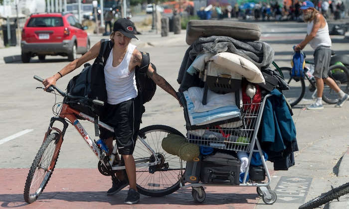Rick Egan  |  The Salt Lake Tribune

Amy Baeschel drags a shopping cart full of her belongings as she and other homeless campers are  forced to remove their belonging from the Rio Grande Area, as the Salt Lake County Health Department brings in heavy machinery to clean up the area, Thursday, July 6, 2017.