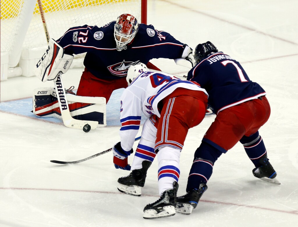 Columbus Blue Jackets goalies Sergei Bobrovsky, left, of Russia, stops a shot by New York Rangers defenseman Brendan Smith, center, as Blue Jackets defenseman Jack Johnson defends during the third period of an NHL hockey game in Columbus, Ohio, Friday, Nov. 17, 2017. (AP Photo/Paul Vernon)