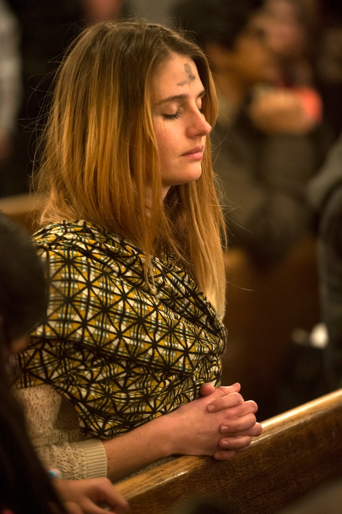 (Rick Egan | The Salt Lake Tribune) A partitioner prays during the Ash Wednesday Mass, at the Cathedral of The Madeleine, Wednesday, Feb. 14, 2018.