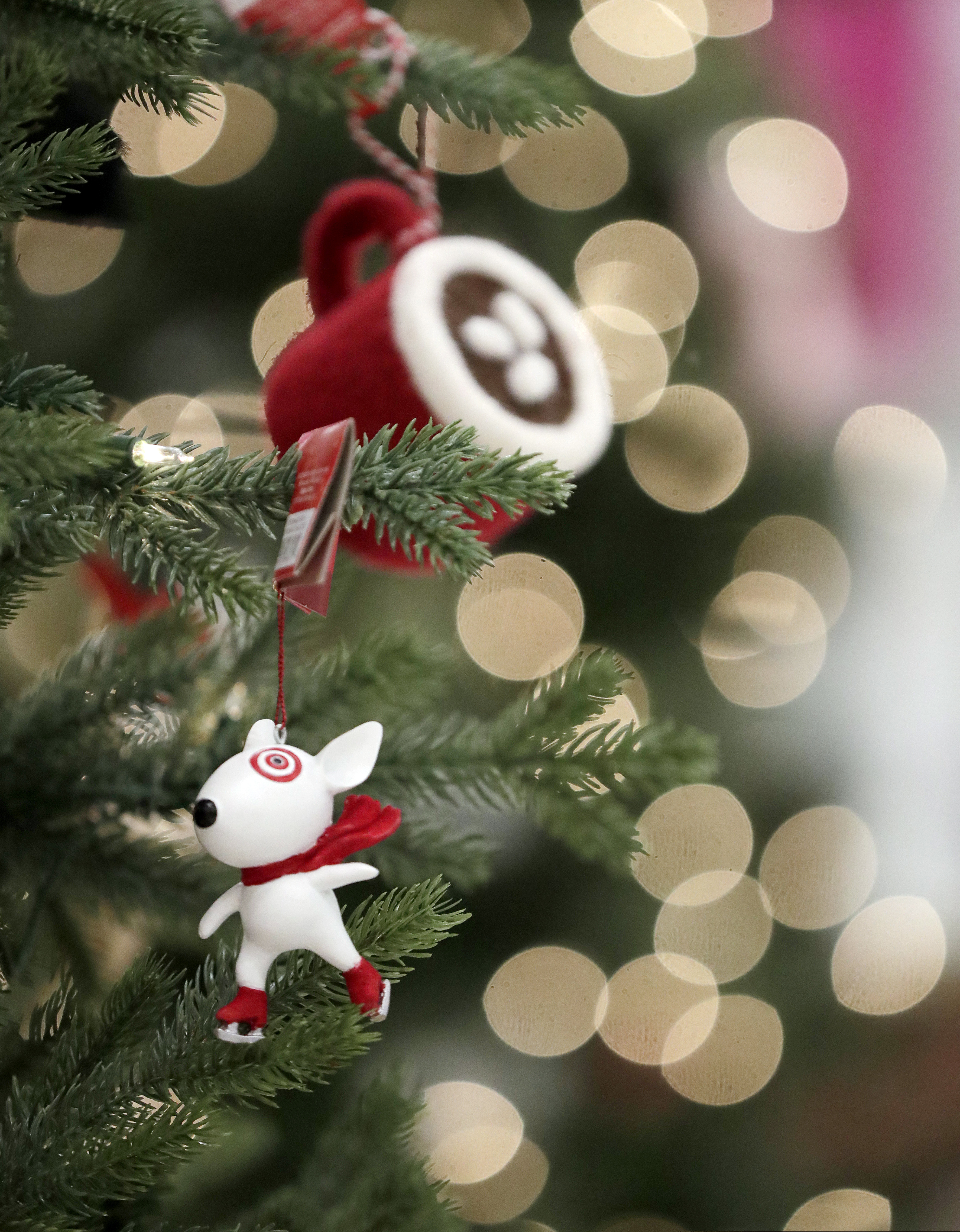 In this Friday, Nov. 16, 2018, photo, ornaments, including one with the likeness of Bullseye, the Target mascot, hang from a display at a Target store in Bridgewater, N.J. Shoppers are spending freely heading into the holidays, but heavy investments and incentives like free shipping by retailers are giving Wall Street pause. Target Inc., Kohl's Corp., Best Buy Co. and TJX Cos. all reported strong sales at stores opened at least a year. (AP Photo/Julio Cortez)